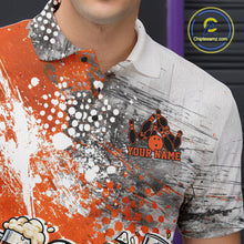 Load image into Gallery viewer, Close-up view of the left chest of an orange and white grunge splatter polo shirt showing humorous bowling ball and pin fighting illustration detail.