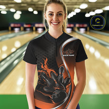 Load image into Gallery viewer, Female model front view in bowling alley wearing black and orange quarter zip shirt with flame bowling action graphics