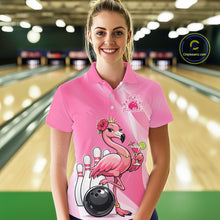Load image into Gallery viewer, Female model wearing a pink bowling polo shirt at a bowling lane with a crowned flamingo, cocktail, bowling ball, and hibiscus flower artwork.