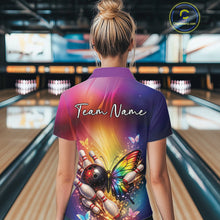 Load image into Gallery viewer, Back view of a female model in a bowling alley wearing a bowling polo shirt showcasing a rainbow butterfly beside a bowling ball and bowling pins.