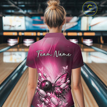 Load image into Gallery viewer, Back view of a female model in a bowling venue wearing a pink polo shirt featuring a butterfly beside a bowling ball and pins.