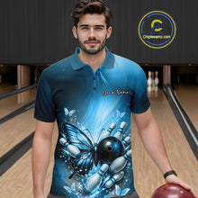 Load image into Gallery viewer, Male model wearing a blue bowling polo shirt at a bowling lane with butterfly artwork, a bowling ball, and scattered pin graphics.