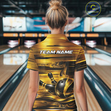Load image into Gallery viewer, Back view of a female model inside a bowling center wearing a bowling polo shirt with glossy gold and black bowling ball and pins artwork.