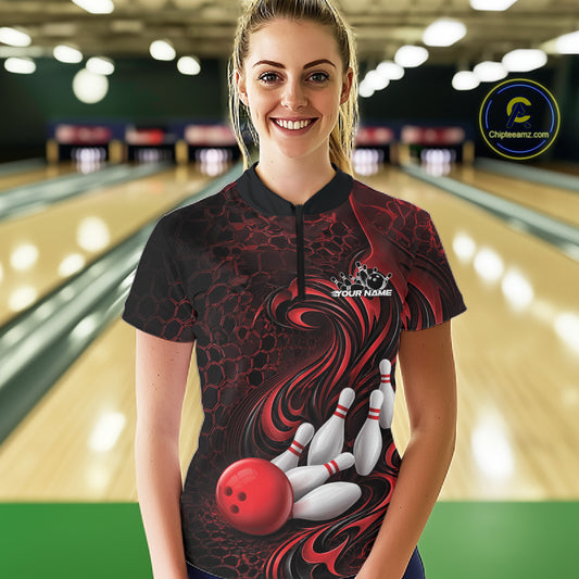 Female model wearing a black and red bowling quarter-zip shirt in a bowling alley featuring a tribal flame bowling ball and pins graphic
