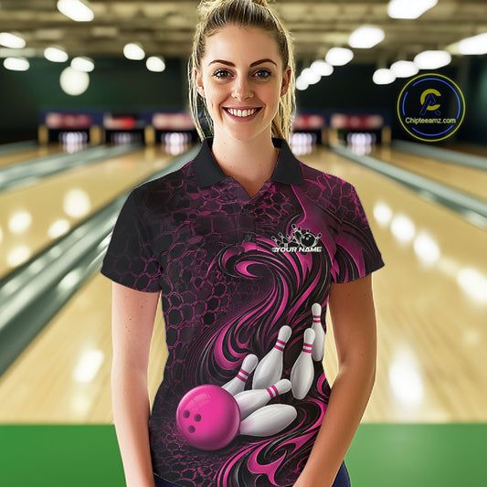 Female model wearing a black and pink bowling polo shirt in a bowling alley featuring a tribal flame bowling ball and pins graphic