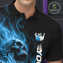 Load image into Gallery viewer, Close-up of the left chest on a black bowling polo shirt featuring a skull clutching a bowling ball surrounded by swirling blue energy flames