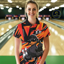 Load image into Gallery viewer, Female model wearing a black and orange bowling polo in a bowling lane with duck-themed graphics and geometric background accents.