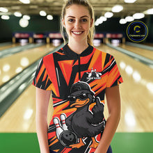 Load image into Gallery viewer, Female model wearing a black and orange bowling quarter-zip at the bowling lane with duck artwork, bowling pins, and geometric accents.