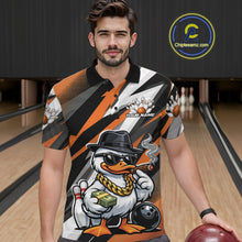 Load image into Gallery viewer, Male model wearing a black and orange bowling polo in a bowling center featuring a duck illustration beside bowling pins and ball.