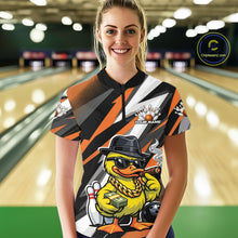 Load image into Gallery viewer, Front view female model at bowling lane wearing black and orange quarter zip shirt showcasing duck in sunglasses and fedora with bowling ball and pins illustration.