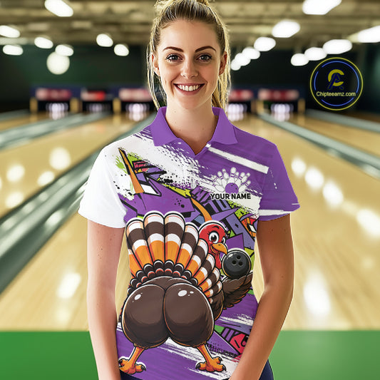 Front view of a female model wearing a purple custom bowling polo shirt with a funny graffiti turkey holding a bowling ball, paint splatter accents, and a personalized name in a bowling alley.