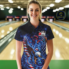 Load image into Gallery viewer, Female model front view in a bowling lane wearing a polo shirt with flaming bald eagle artwork, blue bowling ball, American flag, and blue flames.