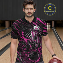 Load image into Gallery viewer, Male model at a bowling lane wearing a black and pink bowling polo shirt with a patriotic flaming bowling ball striking pins and American flag graphics.