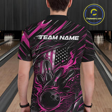 Load image into Gallery viewer, Back view of a male model in a bowling alley wearing a black and pink polo shirt featuring a fiery bowling strike design with patriotic accents.