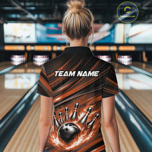 Load image into Gallery viewer, Back view of a female model in a bowling alley wearing a black and orange polo shirt featuring a fiery bowling action scene.