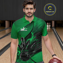 Load image into Gallery viewer, Male model wearing a black and green bowling polo shirt at a bowling lane with fiery bowling strike artwork and hexagonal graphics.