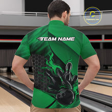 Load image into Gallery viewer, Front view of a male model in a bowling alley wearing a black and green quarter-zip shirt featuring a flaming bowling ball hitting the pins.