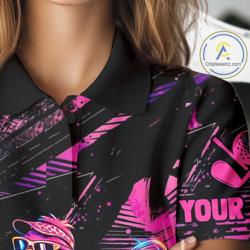 Black shirt with pink and purple designs and text held by a person