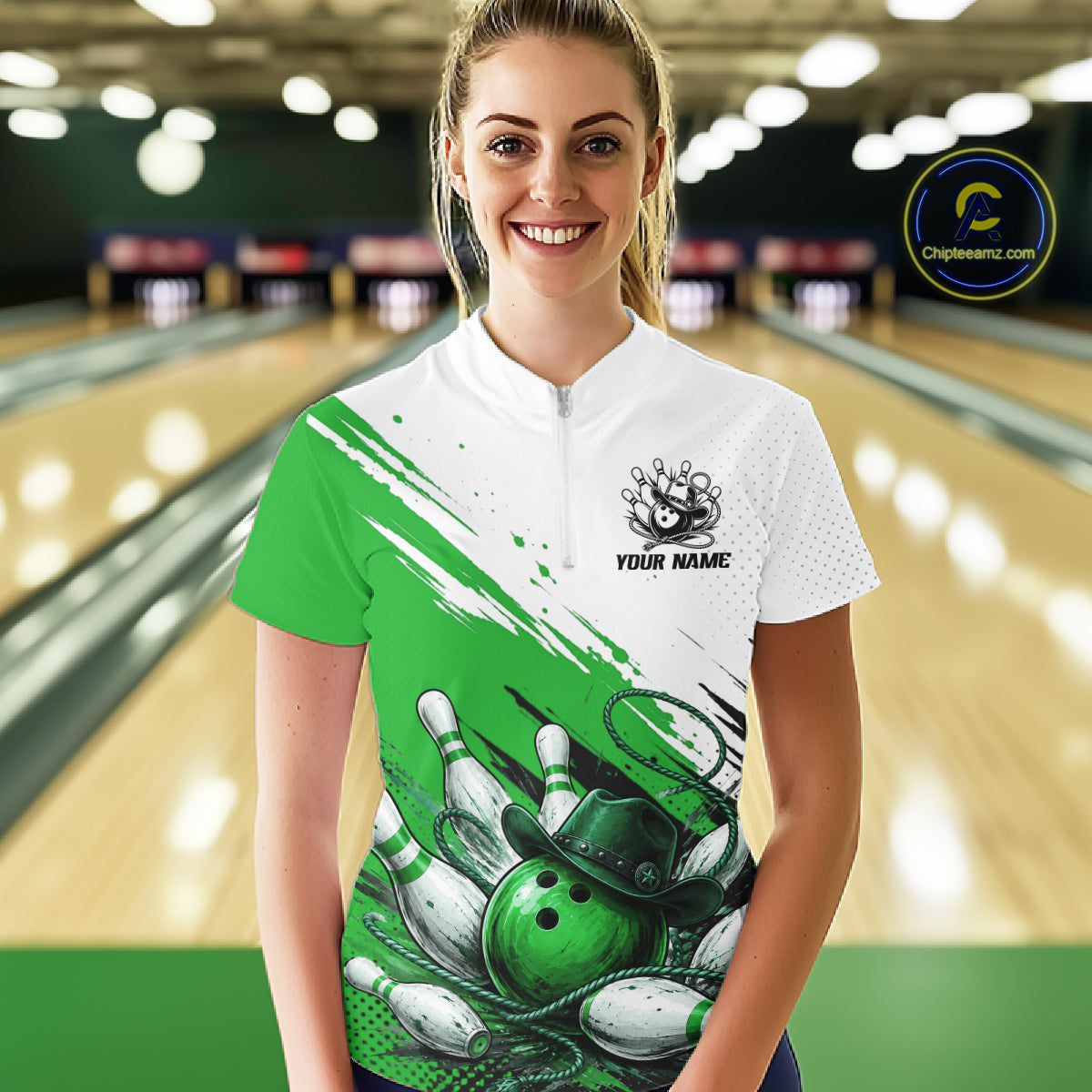 A woman stands in a bowling alley wearing a short-sleeve bowling jersey with a green and white graphic design featuring bowling pins and balls, a bowling pin hat, and the text 'YOUR NAME'.