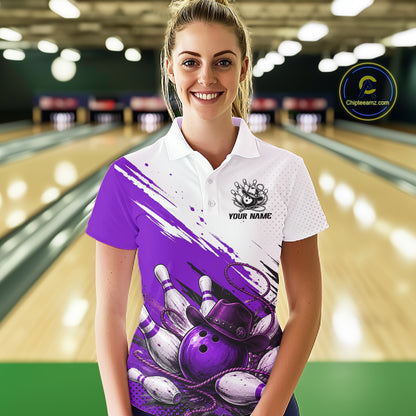 A woman stands in a bowling alley wearing a custom short-sleeve polo shirt with a purple and white bowling graphic design. The shirt features a white upper chest and collar, a purple and white brushstroke pattern across the front, a bowling pin illustration, and a customizable name patch.