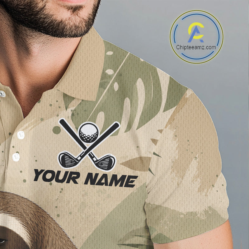 A close-up of a man wearing a short-sleeve polo shirt with a beige and green camouflage pattern, featuring a custom golf graphic with crossed clubs, a golf ball, and the placeholder text 'YOUR NAME'.