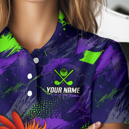 A close-up of a person wearing a short-sleeve polo shirt with a purple and neon green abstract paint-splatter design. The shirt features a custom golf-themed chest graphic with crossed golf clubs, a golf ball, and the placeholder text 'YOUR NAME'.
