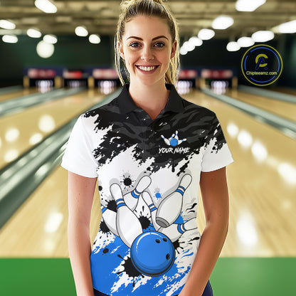 A woman stands in a bowling alley wearing a custom bowling-themed polo shirt. The shirt features a black and white splatter design with a blue bowling ball graphic and the text 'YOUR NAME' and 'CHIPTEEAMZ"