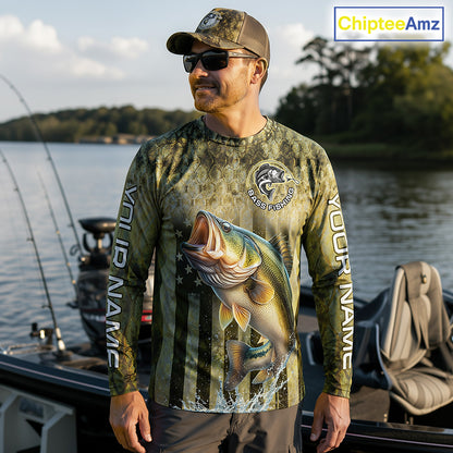 Man wearing a fishing-themed shirt with a large bass graphic on a boat by a lake.