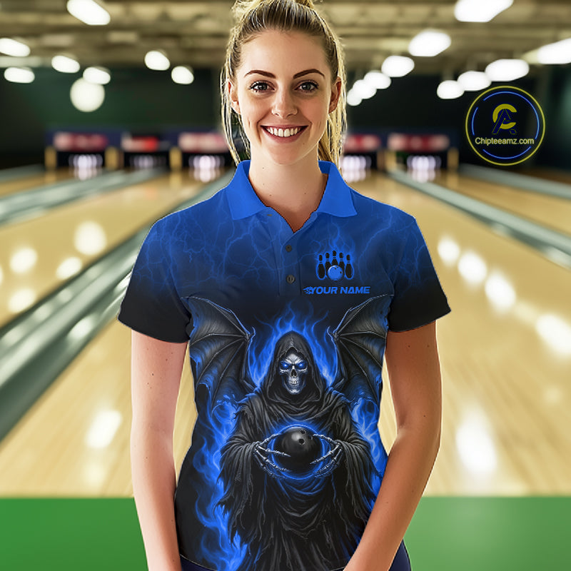 A woman wearing a custom blue and black short-sleeve polo shirt with a grim reaper graphic holding a bowling ball, standing in a bowling alley. The shirt features a blue flame design and a placeholder logo that reads 'YOUR NAME'