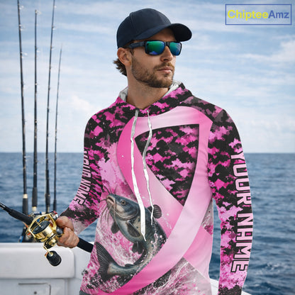 Angler wearing pink ribbon camouflage catfish fishing breast cancer long sleeve hooded sun protection shirt on the water