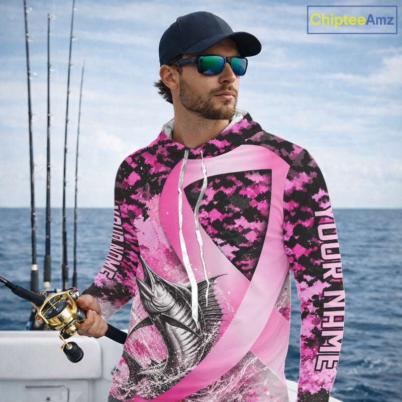 Angler wearing pink ribbon camouflage marlin fishing breast cancer long sleeve hooded sun protection shirt on the water