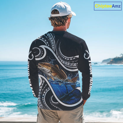 Angler wearing blue tribal pattern custom redfish long sleeve fishing shirt on the water