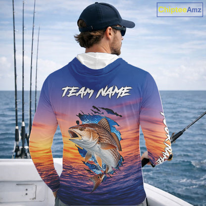 Angler wearing Redfish Fishing Sunset custom long sleeve hooded redfish offshore fishing shirt on the boat at sunset