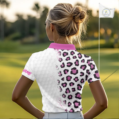 Woman on a golf course wearing a white polo shirt with pink leopard print and 'YOUR NAME' text