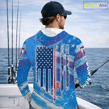 Load image into Gallery viewer, Man on a boat wearing a blue American flag marlin hooded fishing shirt with custom name on the sleeves