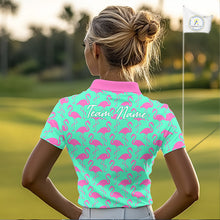 Load image into Gallery viewer, Woman wearing a green polo shirt with pink flamingo pattern and 'Team Name' text on the back, standing on a golf course.
