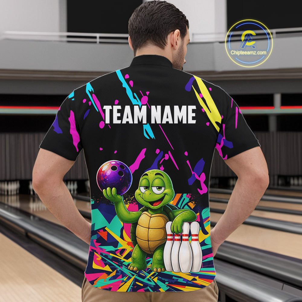 Person wearing a colorful bowling-themed shirt with a turtle design in a bowling alley.