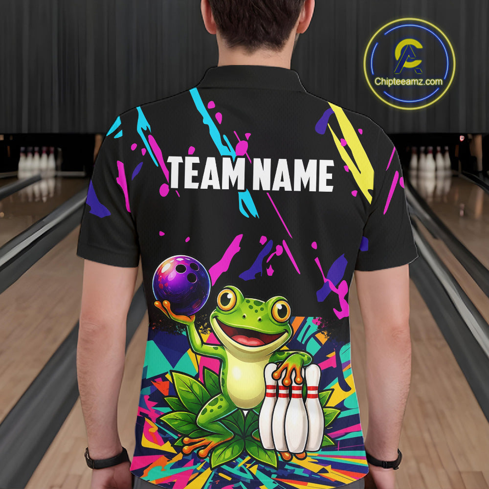 Person wearing a black bowling shirt with colorful design and frog graphic in a bowling alley.
