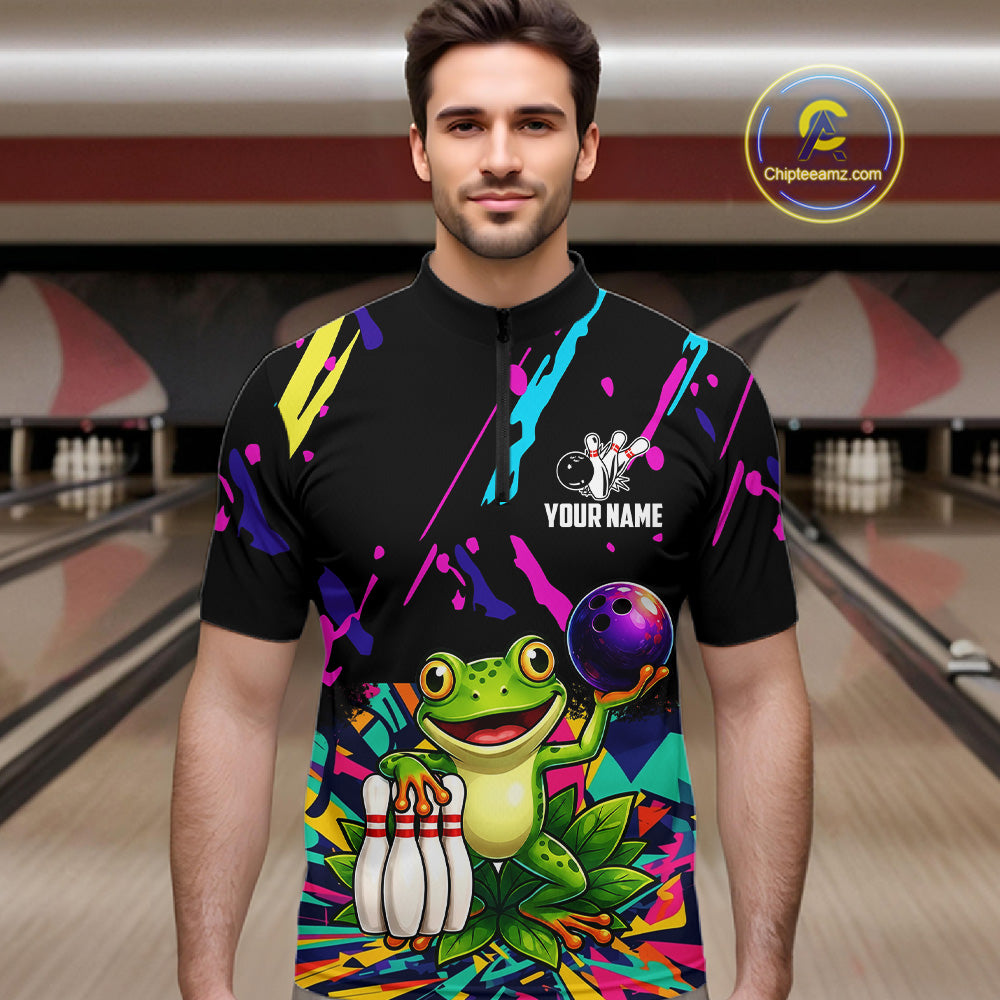 Man wearing a colorful bowling shirt with a frog graphic in a bowling alley.