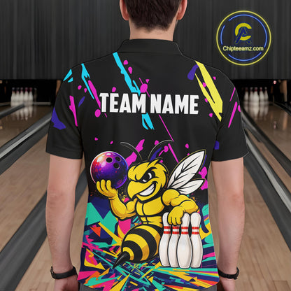 Person wearing a black bowling shirt with colorful design and bee graphic in a bowling alley.