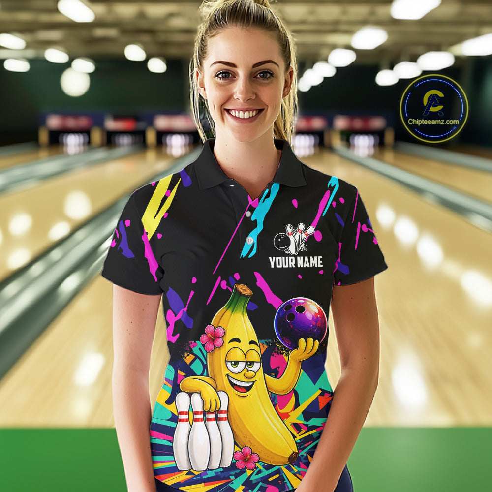 Woman wearing a colorful bowling shirt with a cartoon banana character in a bowling alley.