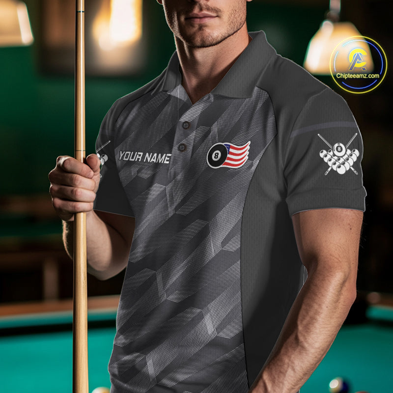 Man wearing a metal grey American flag 8 ball billiard jersey beside a pool table front view.