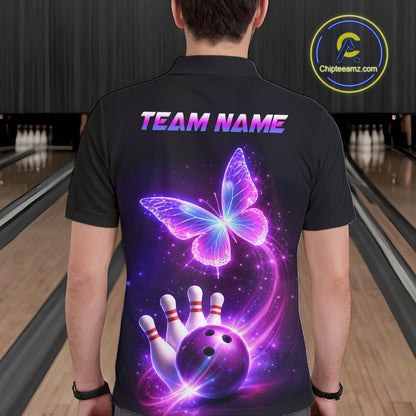 Person wearing a black bowling shirt with a butterfly and bowling ball design, standing in a bowling alley.