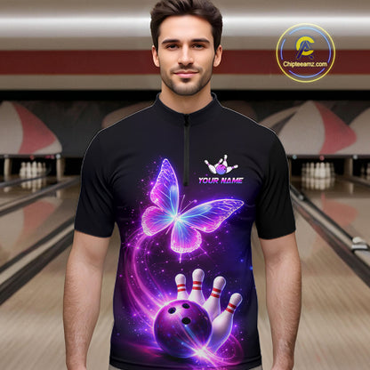 Man wearing a black bowling shirt with a butterfly design in a bowling alley.