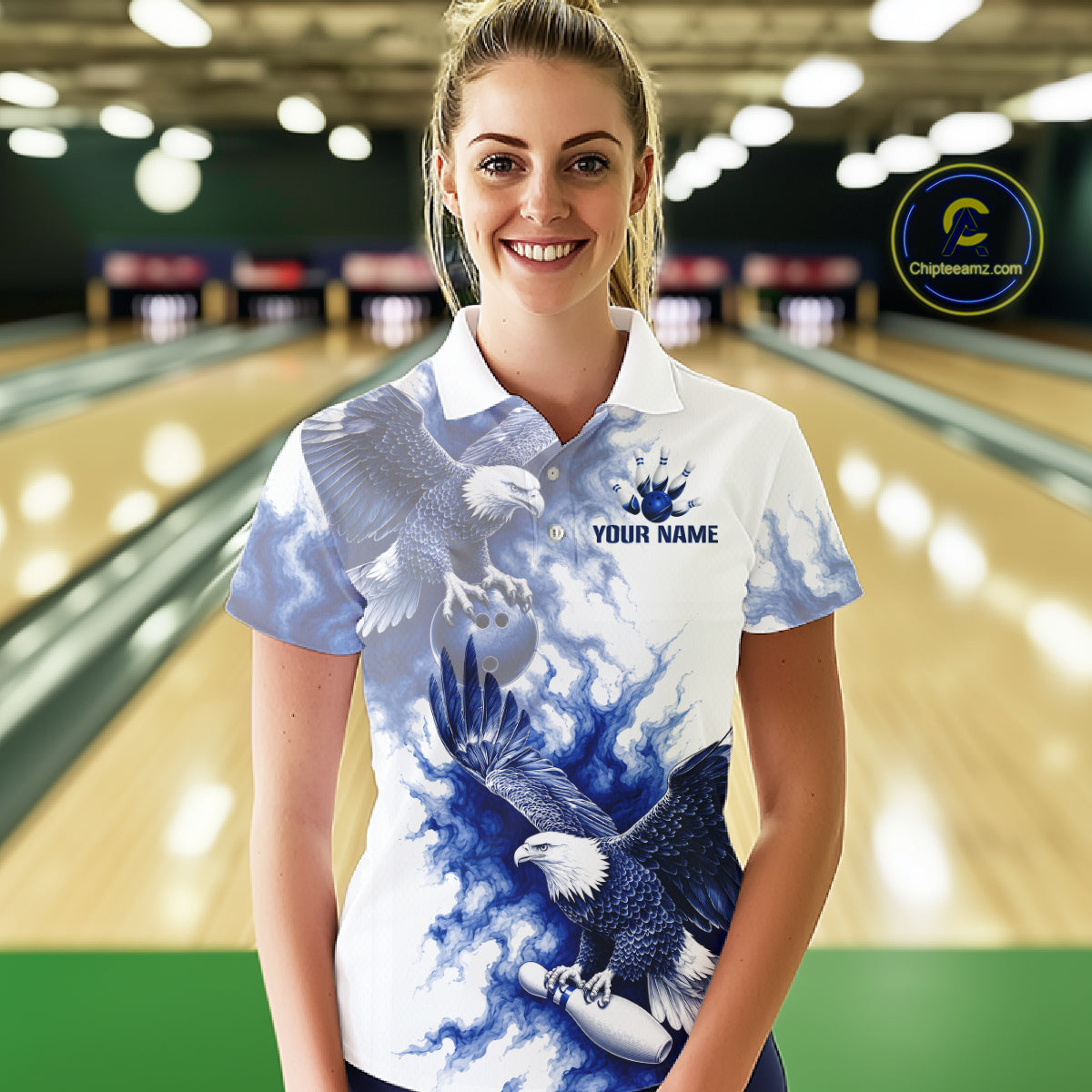 Female bowler wearing Blue & White Eagle bowling jersey in bowling alley, eagle symbolizes freedom, courage, victory, American heritage, personalized tournament apparel.